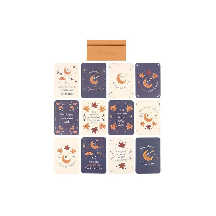 A set of autumn-themed greeting cards and an envelope arranged on a plain white background. The cards feature illustrations of crescent moons, stars, leaves, and fall elements in navy blue, cream, and orange-brown tones.