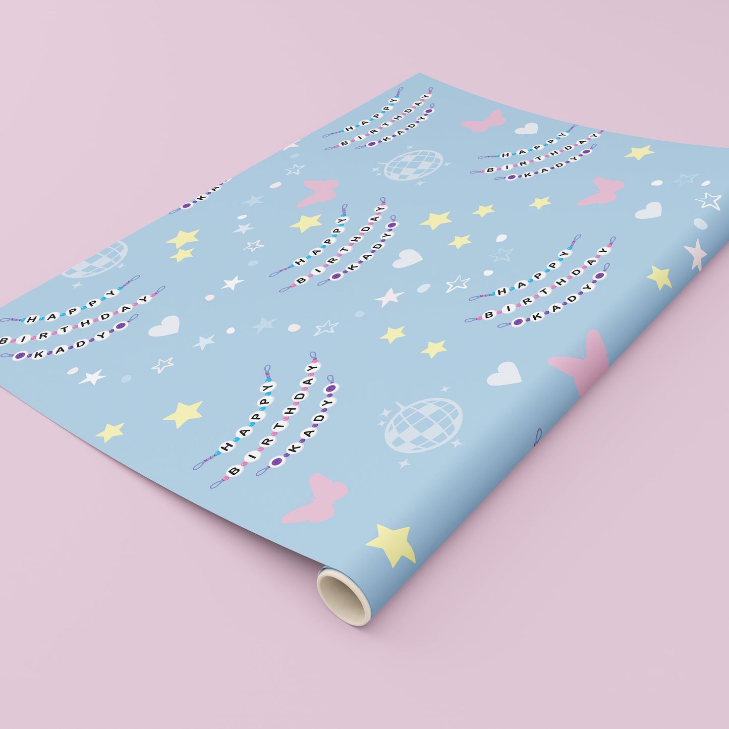 Custom personalised birthday wrapping paper featuring a friendship bracelet style name design repeated across a pastel blue background with stars, hearts, butterflies and disco ball illustrations, ideal for unique birthday gift wrapping.