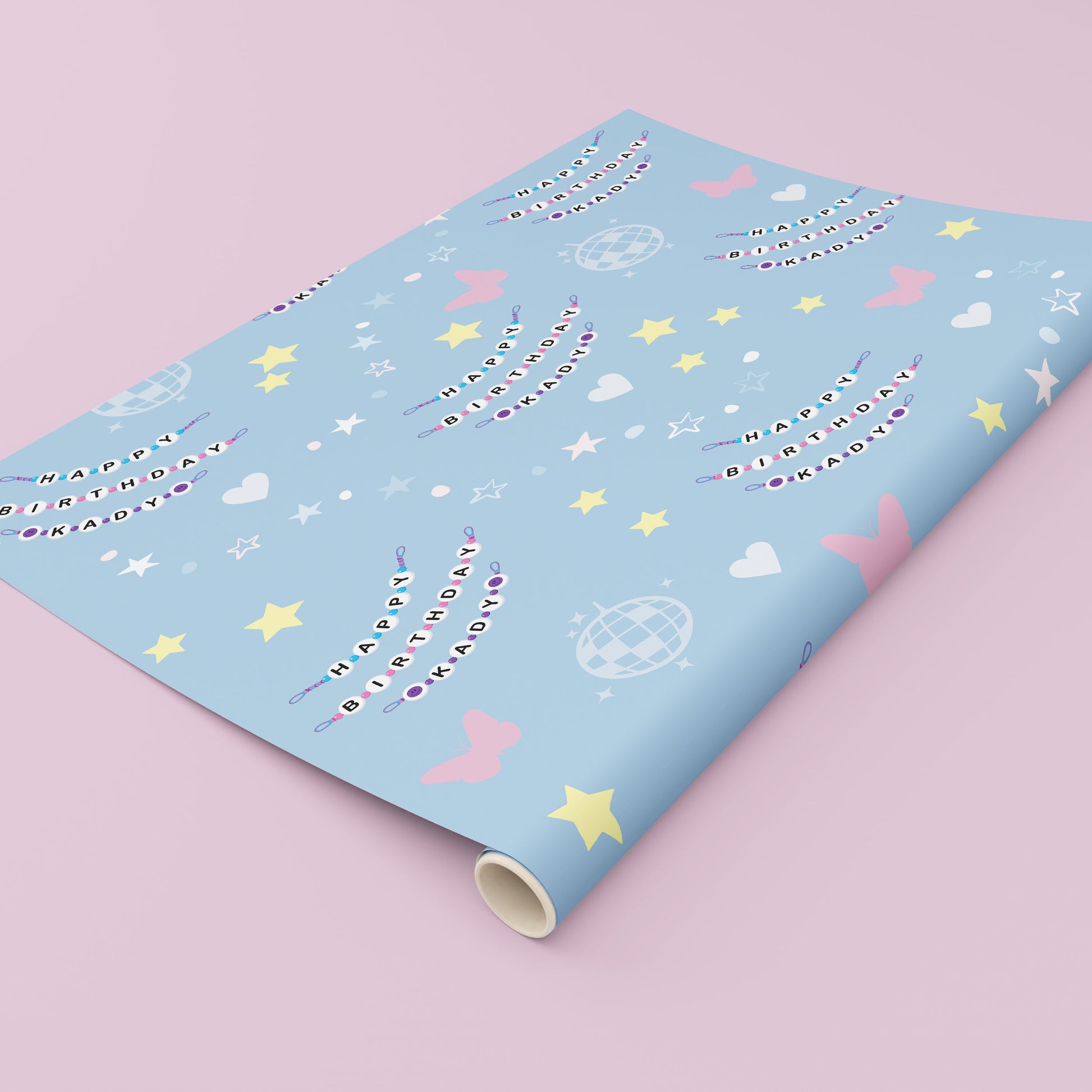 Custom personalised birthday wrapping paper featuring a friendship bracelet style name design repeated across a pastel blue background with stars, hearts, butterflies and disco ball illustrations, ideal for unique birthday gift wrapping.