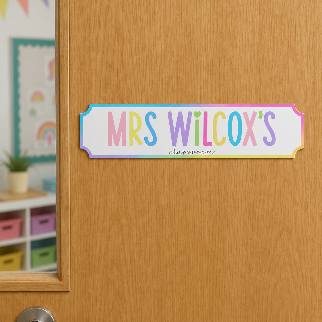 Colorful door sign with 'MRS WILCOX'S CLASSROOM' on a wooden door.